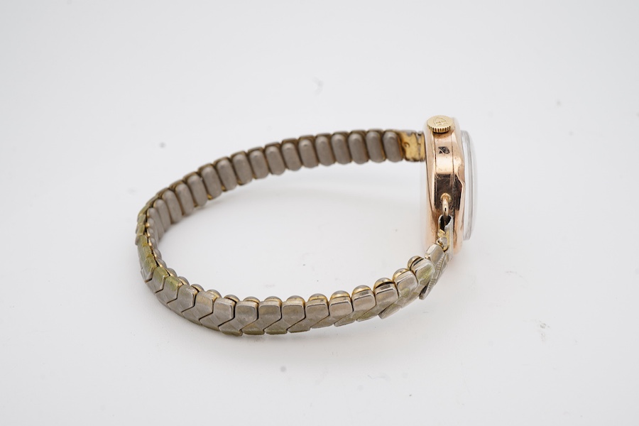 A lady's late 1920's 9ct gold manual wind wristwatch (a.f.), with sunburst Roman dial and unsigned movement, the winding crown with Tudor insignia, on an associated base metal flexible strap.